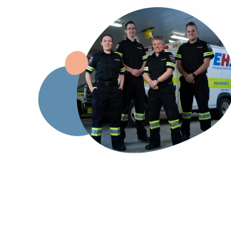 Four paramedics standing in front of an ambulance